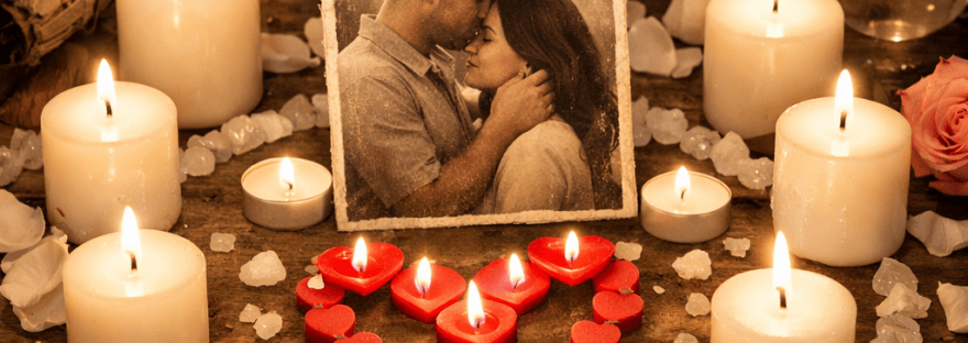 Memorial altar with candles, heart-shaped red candles, couple's photo, crystals, angel statue, and tarot cards